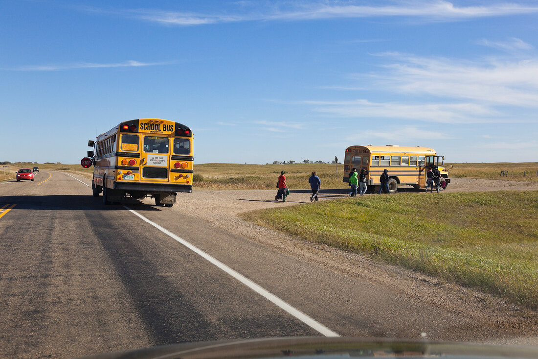 Children at school bus on Highway 15, Saskatchewan, Canada