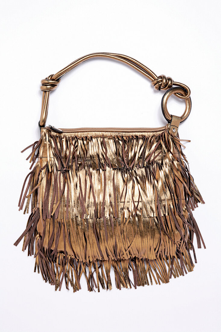 Golden leather bag with fringe on white background