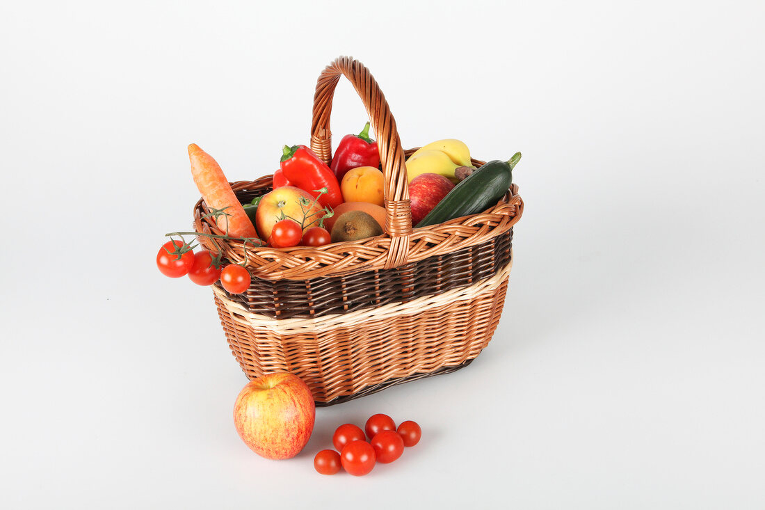 Various vegetables and fruits in basket and front of basket