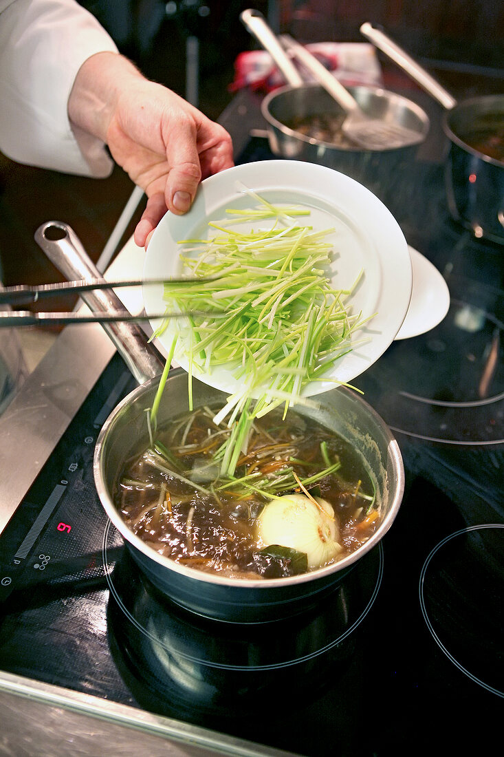 Putting Roots, vegetables and boiled onglet steak in broth