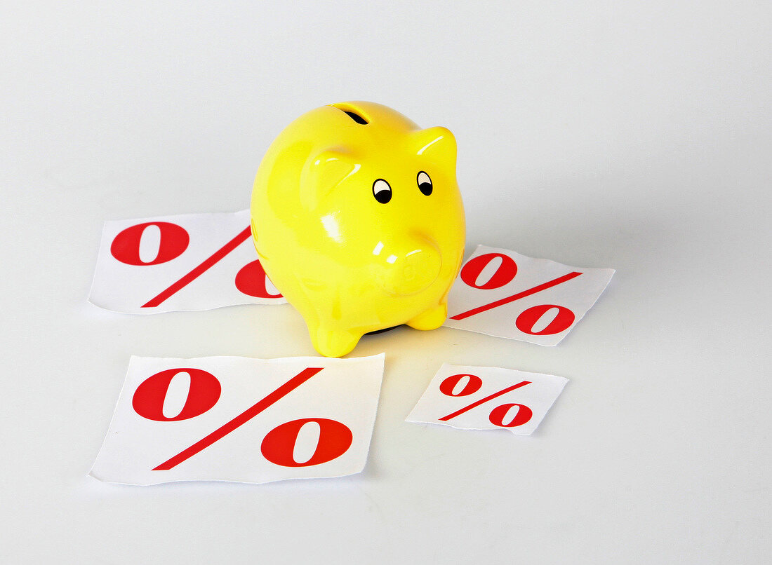 Close-up of yellow piggy bank with percentage sign symbolizing discount
