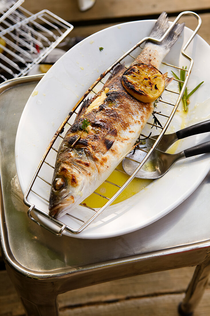 Grilled sea bass with lemon on plate