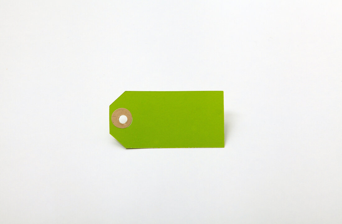 Close-up of green blank tag on white background