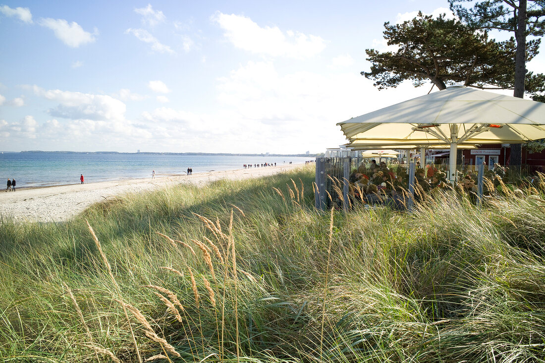 View of beach and Baltic sea beside open cafe, Bay of Lubeck, Schleswig Holstein, Germany
