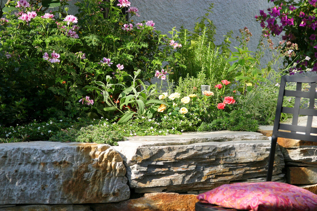 Kräutergarten, Kräuter im Hochbeet, davor ein Stuhl