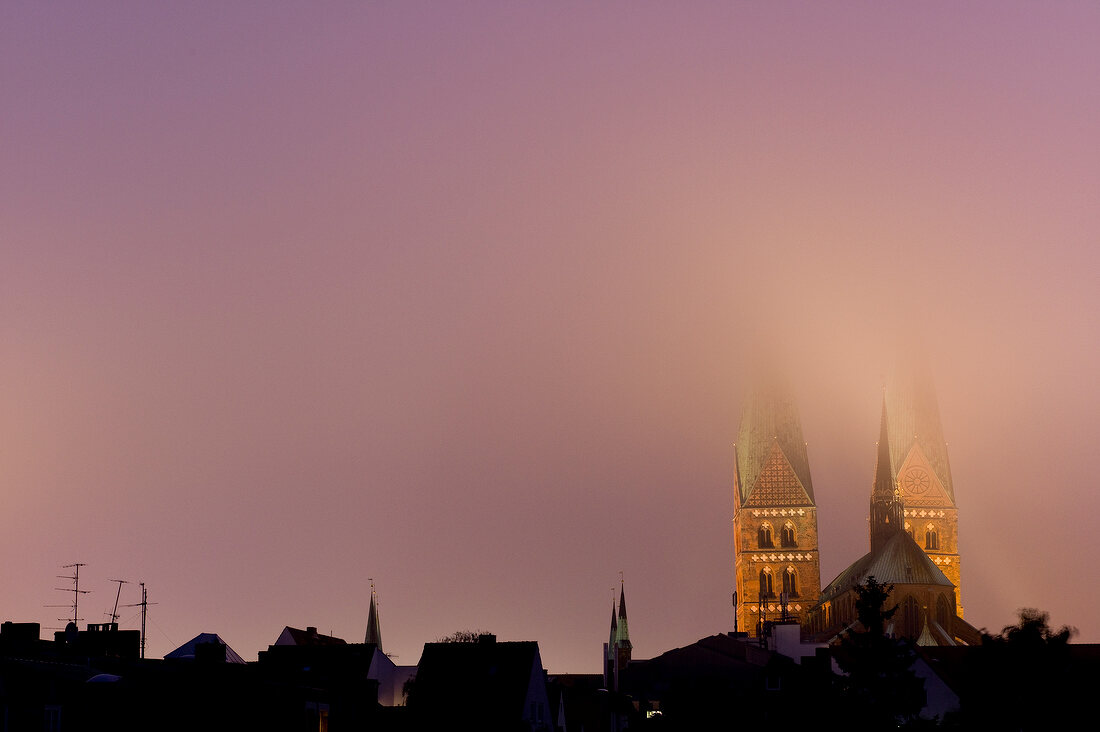 View of town hall towers of St. Mary Church in fog at Lubeck, Schleswig Holstein, Germany