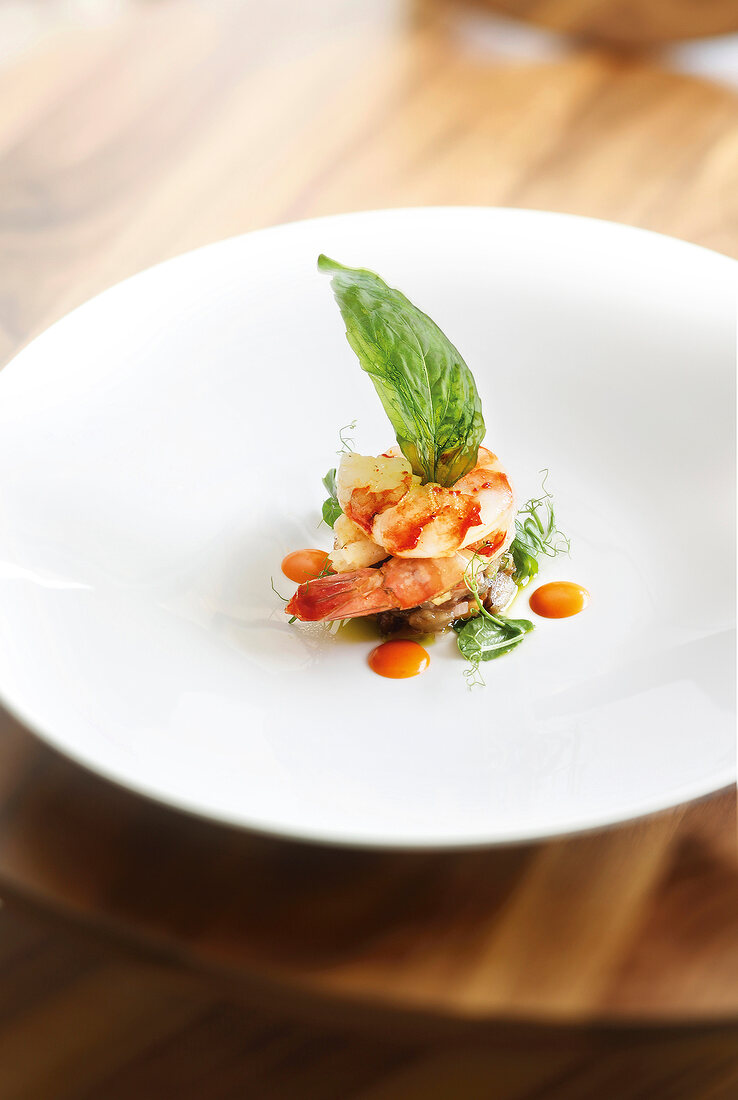 Close-up of scampi with smoked paprika aioli, basil and eggplant on plate