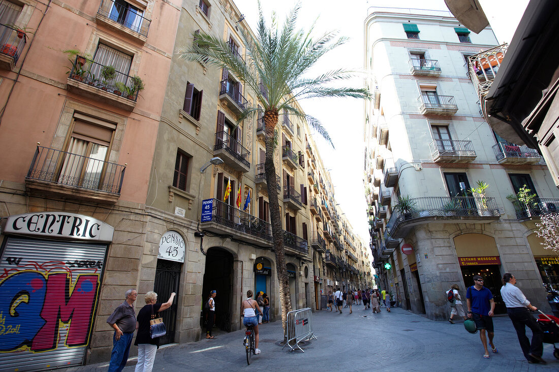 Tourist at Placa Reial alley near sidewalk cafe in Barcelona, Spain