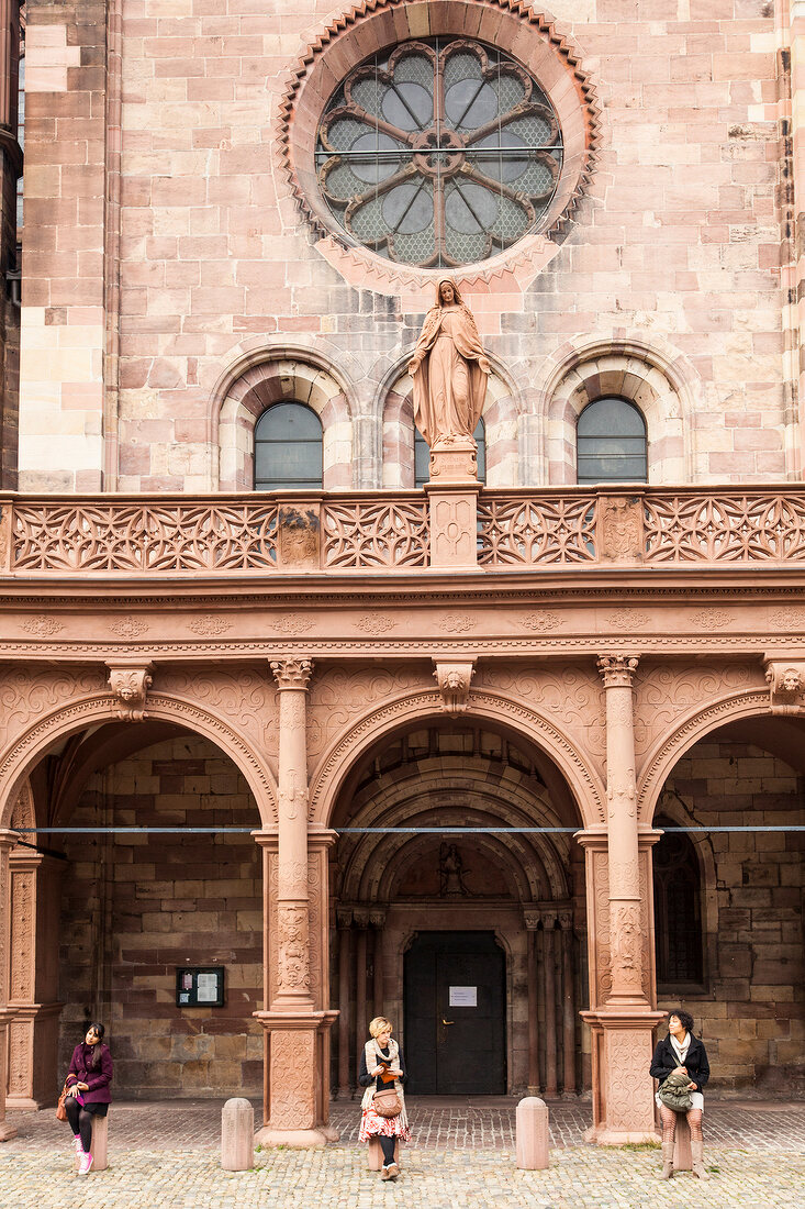 Three woman at the entrance of Freiburg Minster Cathedral, Freiburg, Germany