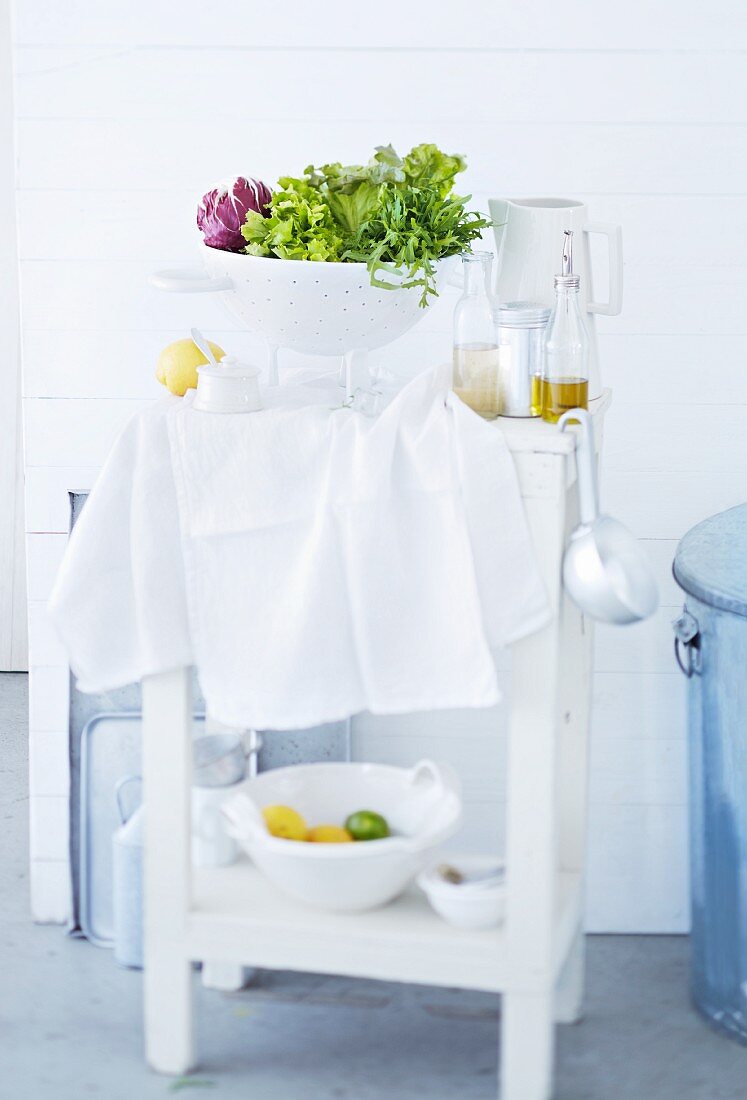Ablagetisch für die Küche mit mit Salat im Seiher & Dressingzutaten