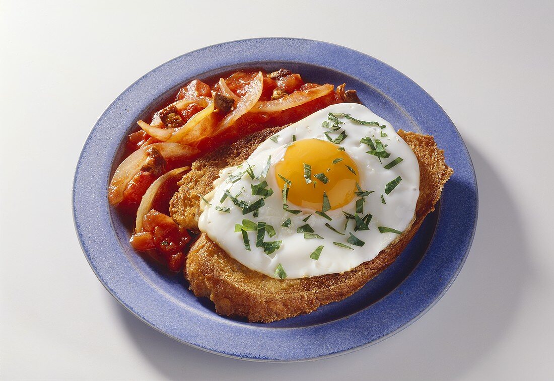 Spiegelei auf Brot mit Tomatengemüse