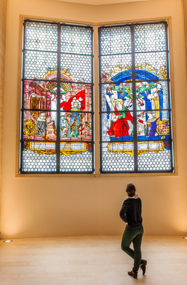 Woman standing in front of Kaiser window, Augustiner Museum, Freiburg, Germany