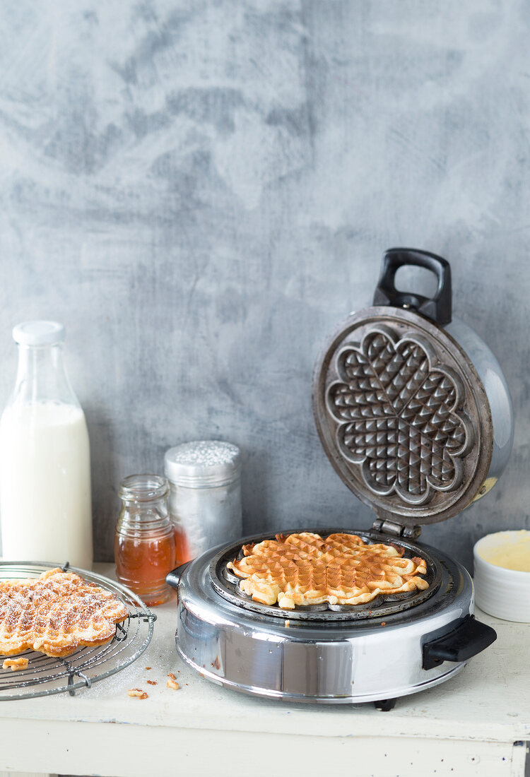 Close-up of round waffle maker with cooked waffle