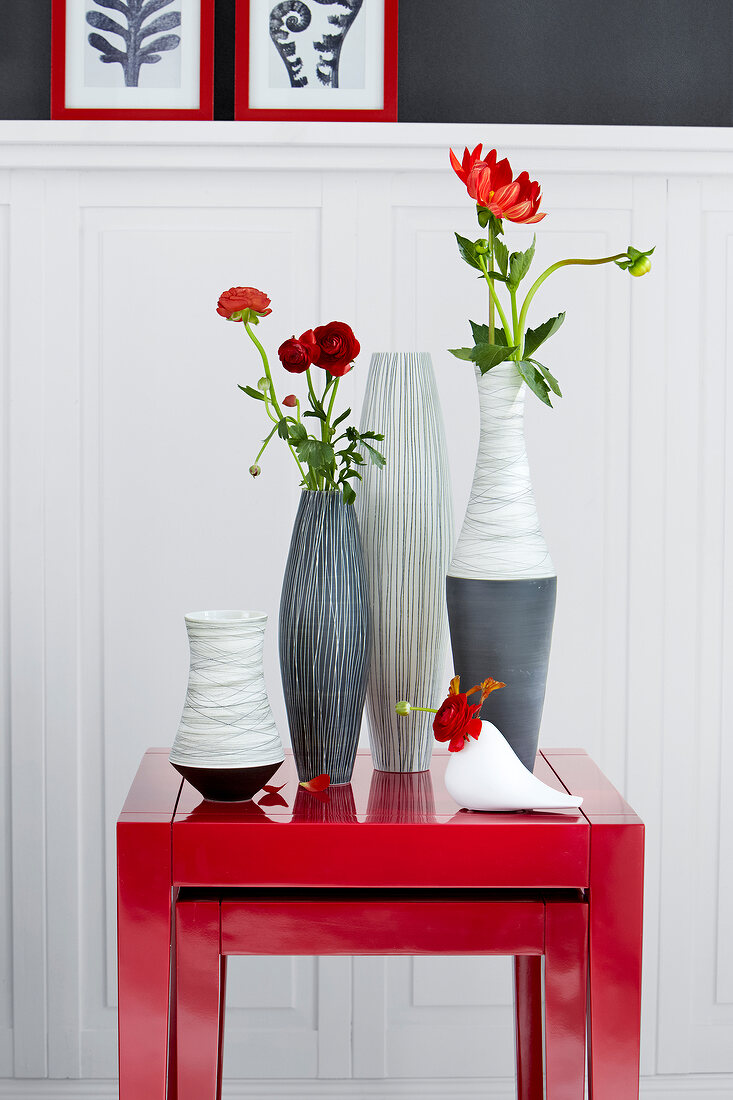 Red side table with various patterned flower vases