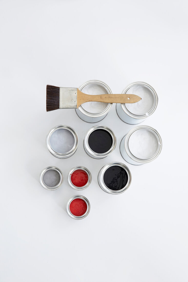 Red, grey, black and white paint in colour pots on white background