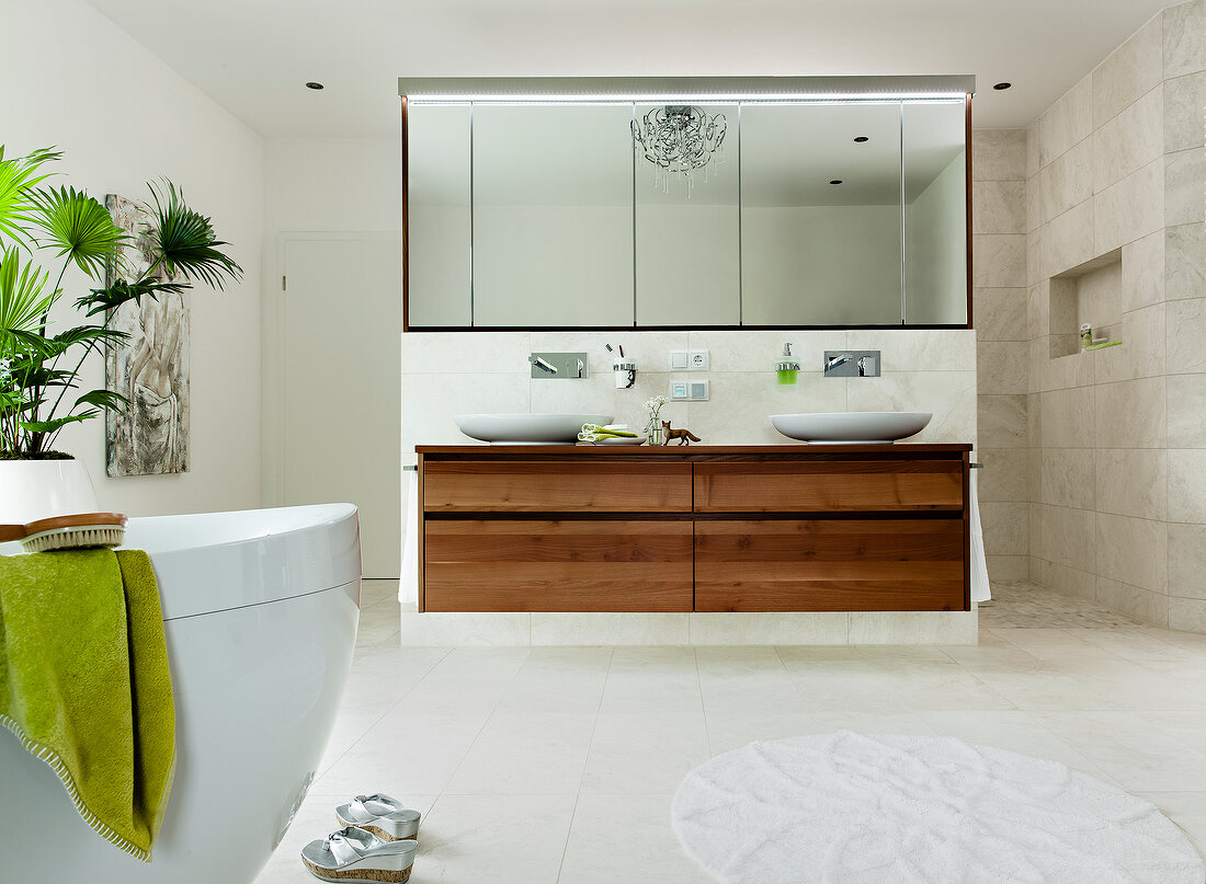 Bad mit ovaler Badewanne, Waschtisch aus Akazienholz, grüne Accessoires