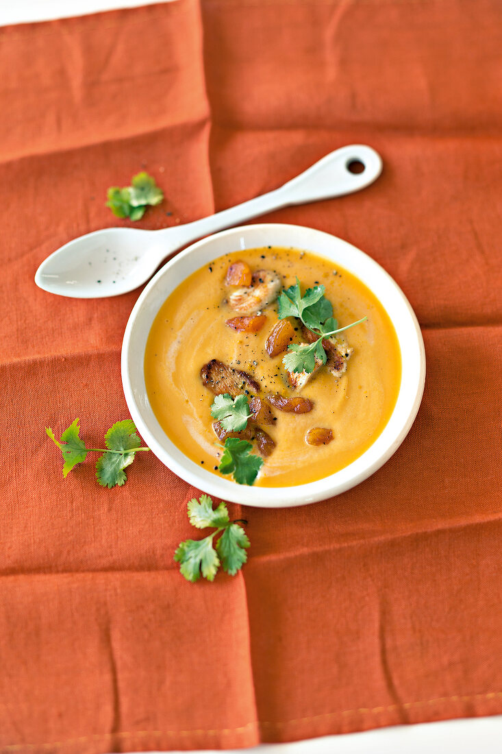 Carrot soup with sweet potato and chicken fillet in bowl