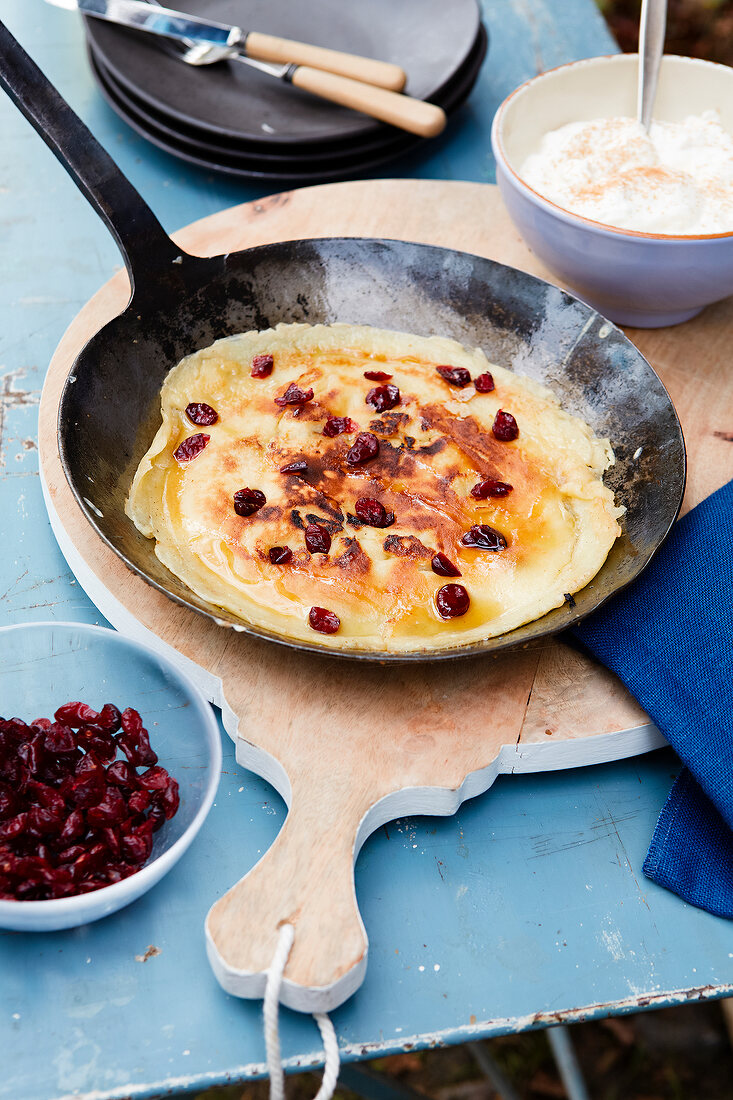 Pancakes with cranberries and walnuts in pan