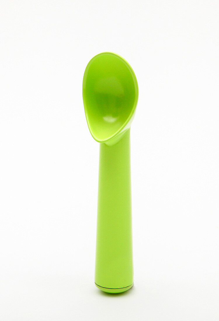 Green ice cream spoon on white background