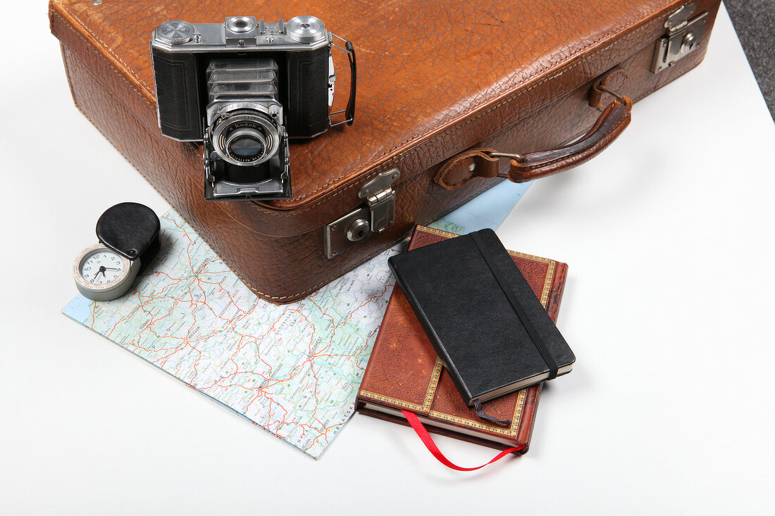Diary, camera, briefcase and map for travel on white background