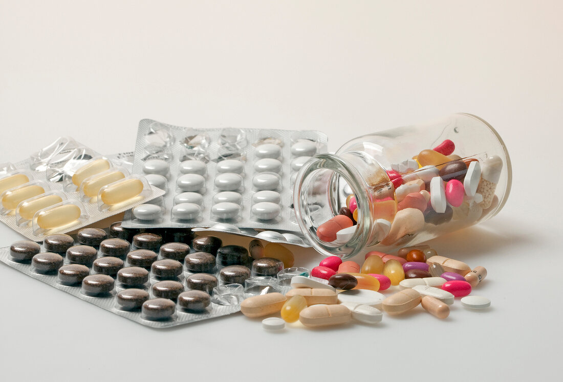 Various pills, capsules and dragees on white background