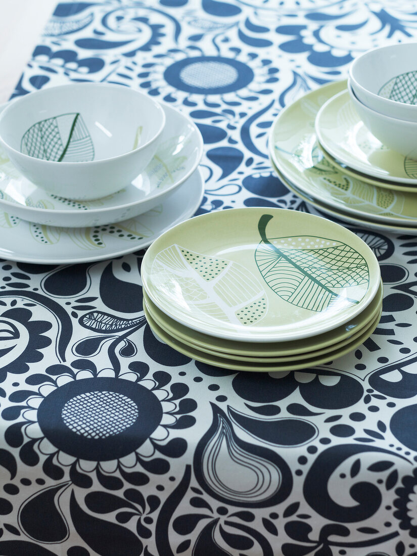 Close-up of patterned dishes on table runner
