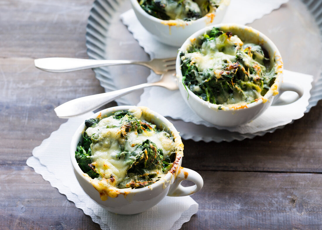 Spinach with cheese topping in bowl