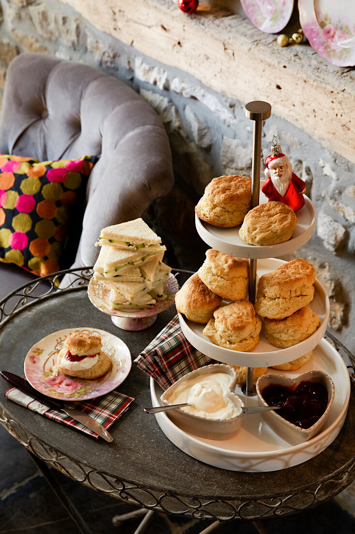 Pastry with jam and cucumber sandwiches on cake stand