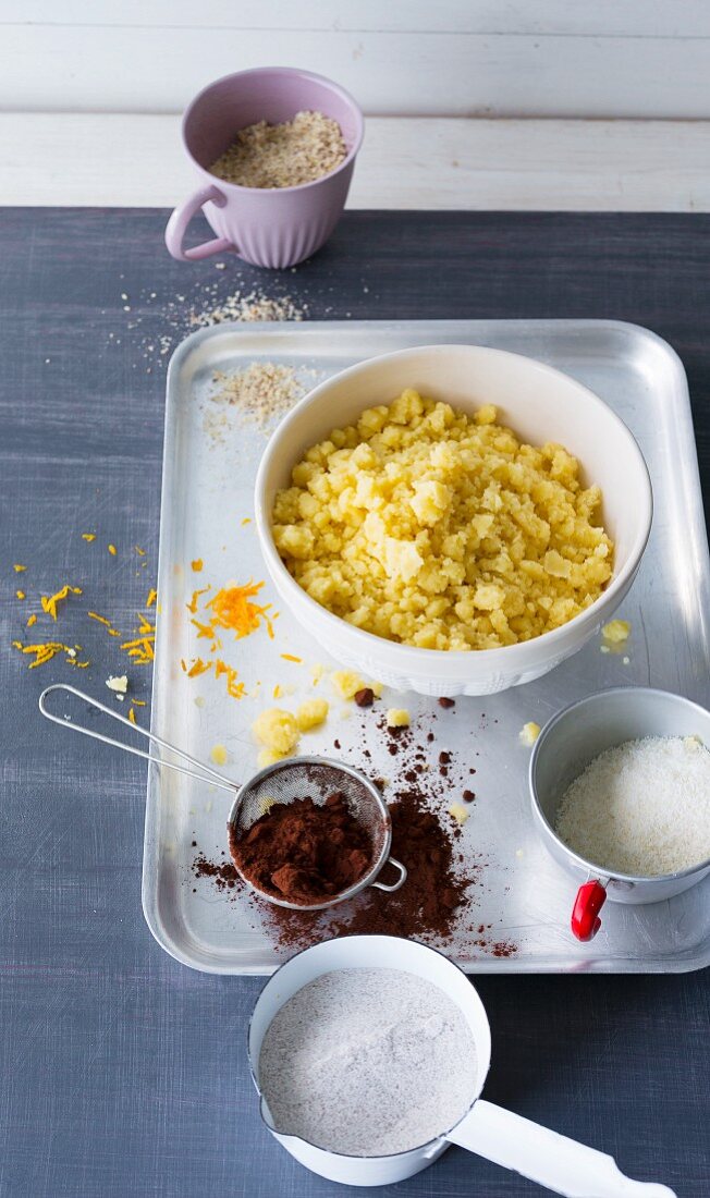 A bowl of crumbles with various ingredients including cocoa, grated chocolate, nuts and sugar