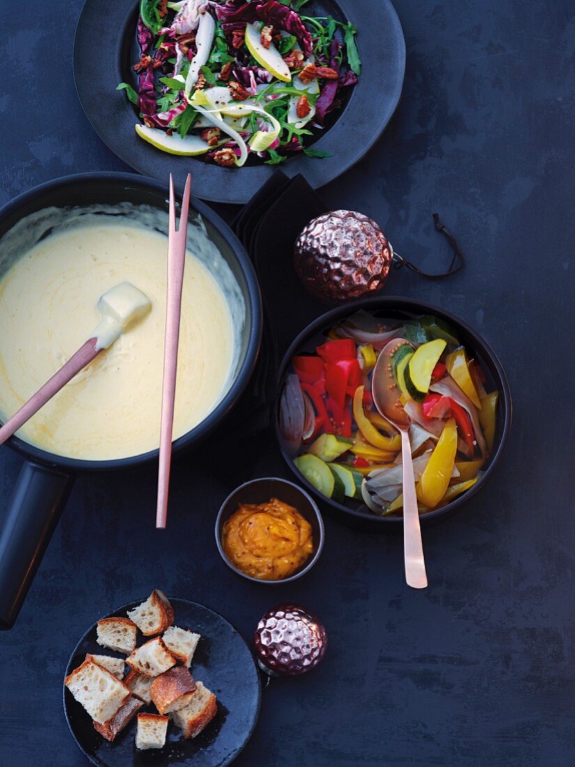 Bitter salads with pears and nuts, a cheese fondue and pickled vegetables