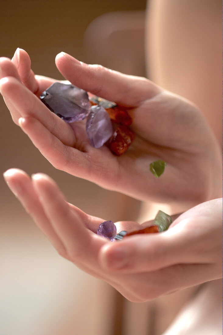 Close-up of different colour gems in hands