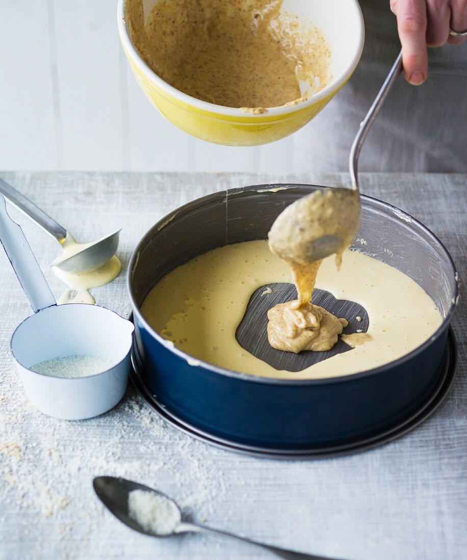 Mandarin marble cake being made – nut cake mix being added to the baking tin