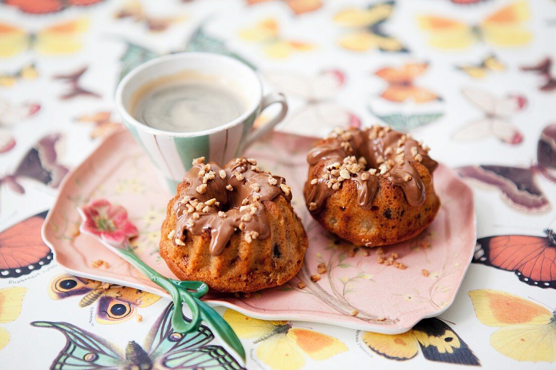 Mini nougat brittle Bundt cakes with apple served with a cup of coffee