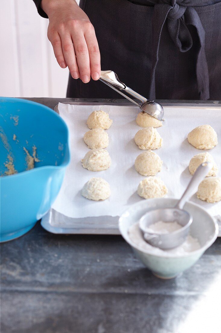 Amarettini being made: batter being place on a baking tray using an ice cream scoop