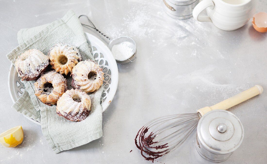 Mini marble Bundt cakes with baking ingredients and utensils