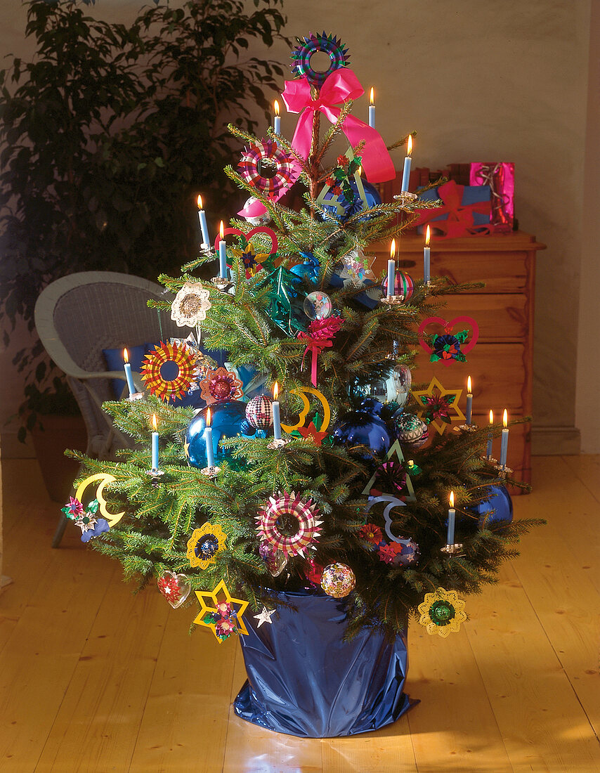 Weihnachtsbaum mit Papierschmuck und Glaskugeln