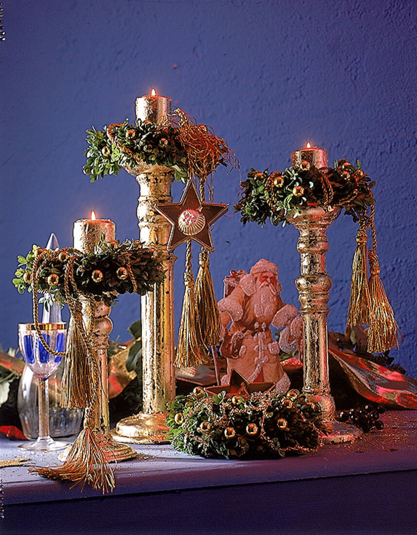 Weihnachtskränze auf goldfarbenen Kerzenleuchtern