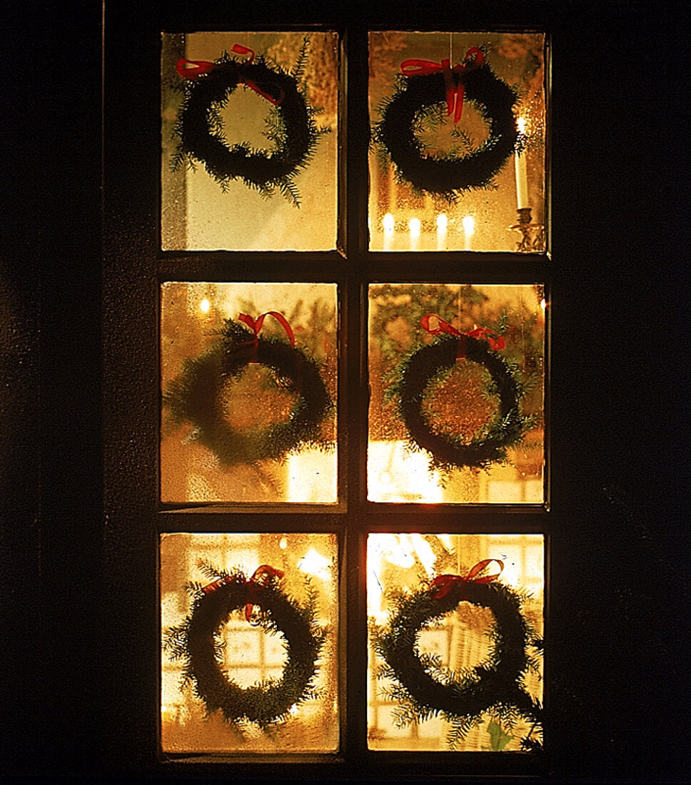 Weihnachtskränze an Außentür, festlich beleuchtet