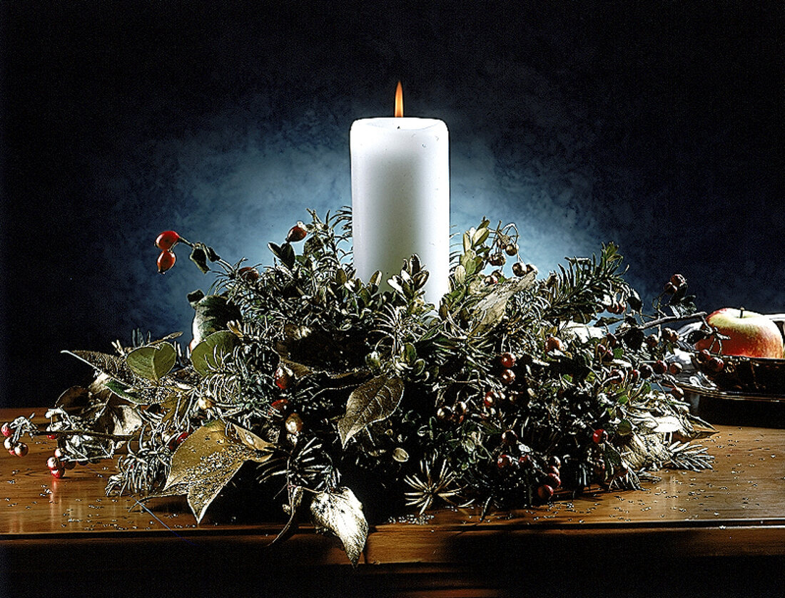 Adventsgesteck mit Goldfarbe besprüht, Hagebutten und weiße Kerze