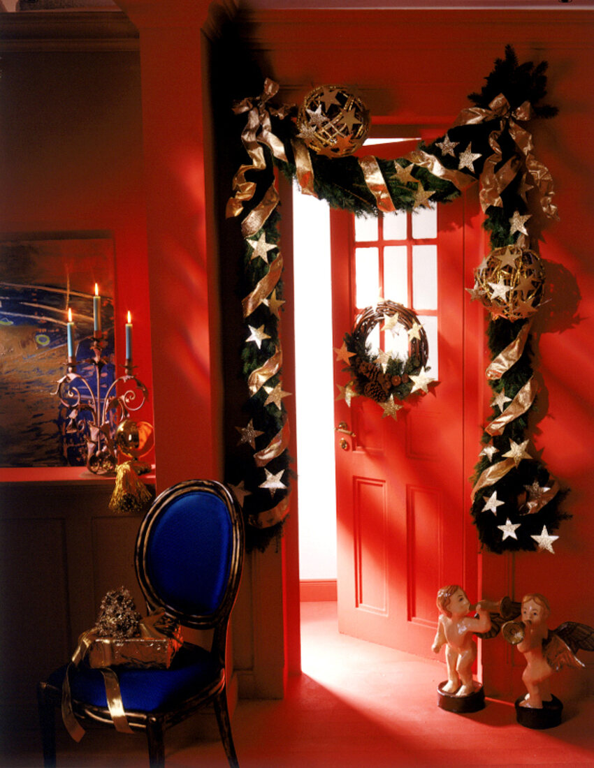 Weihnachtlich dekorierte Tür, rot gestrichene Wände