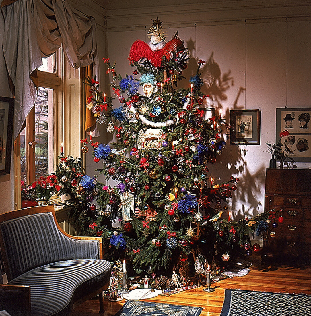 Bunt geschmückter Weihnachtsbaum in Zimmerecke