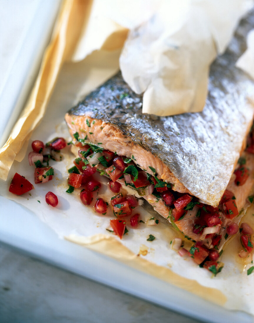 Baked salmon fillet with pomegranate salsa on baking sheet