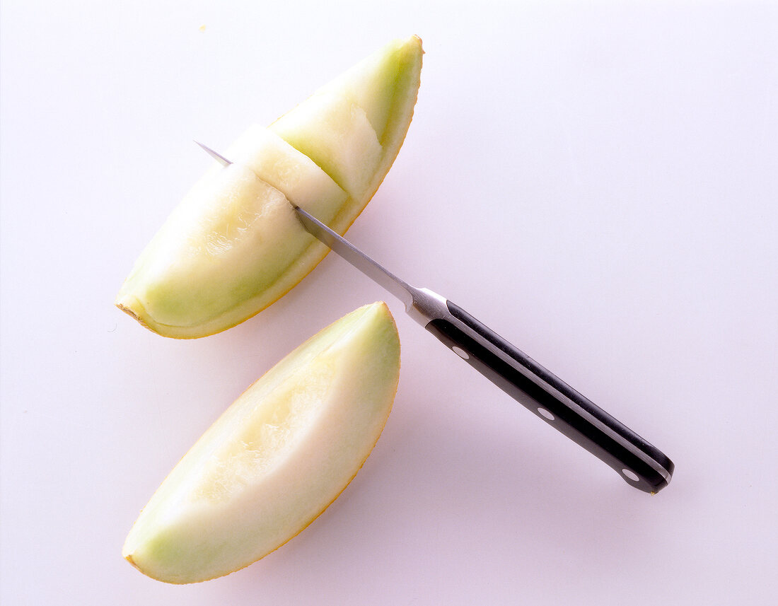 Two slices of honeydew melon on white background