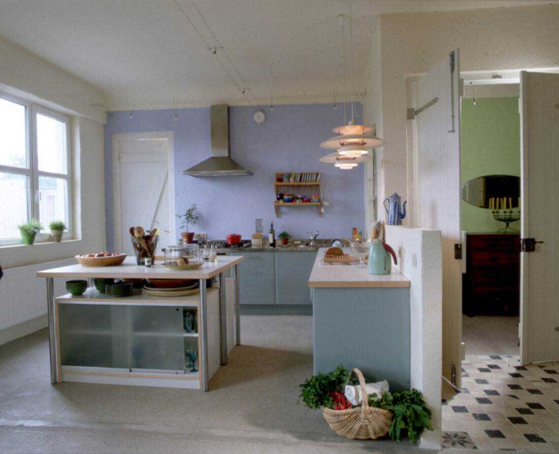 Küche mit hellblaugestrichenen Wänden und Küchenschränken