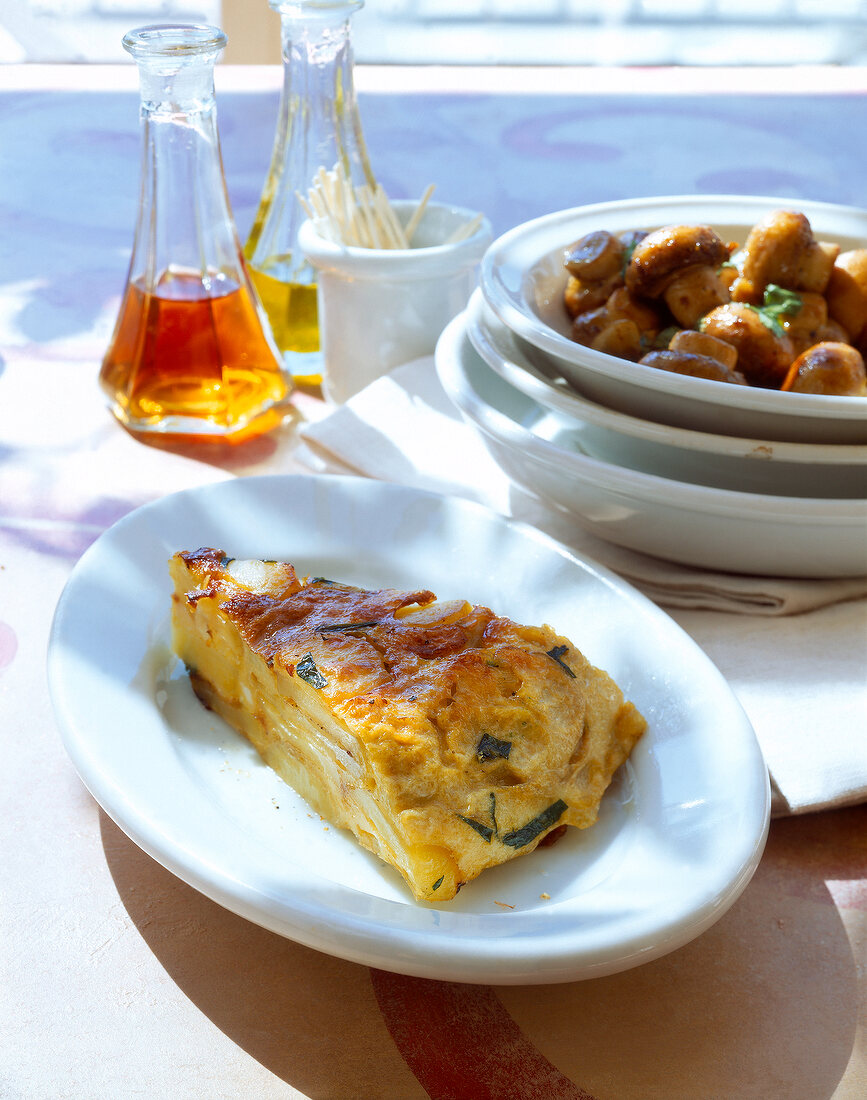 Tortilla on plate and bowl of garlic-mushrooms