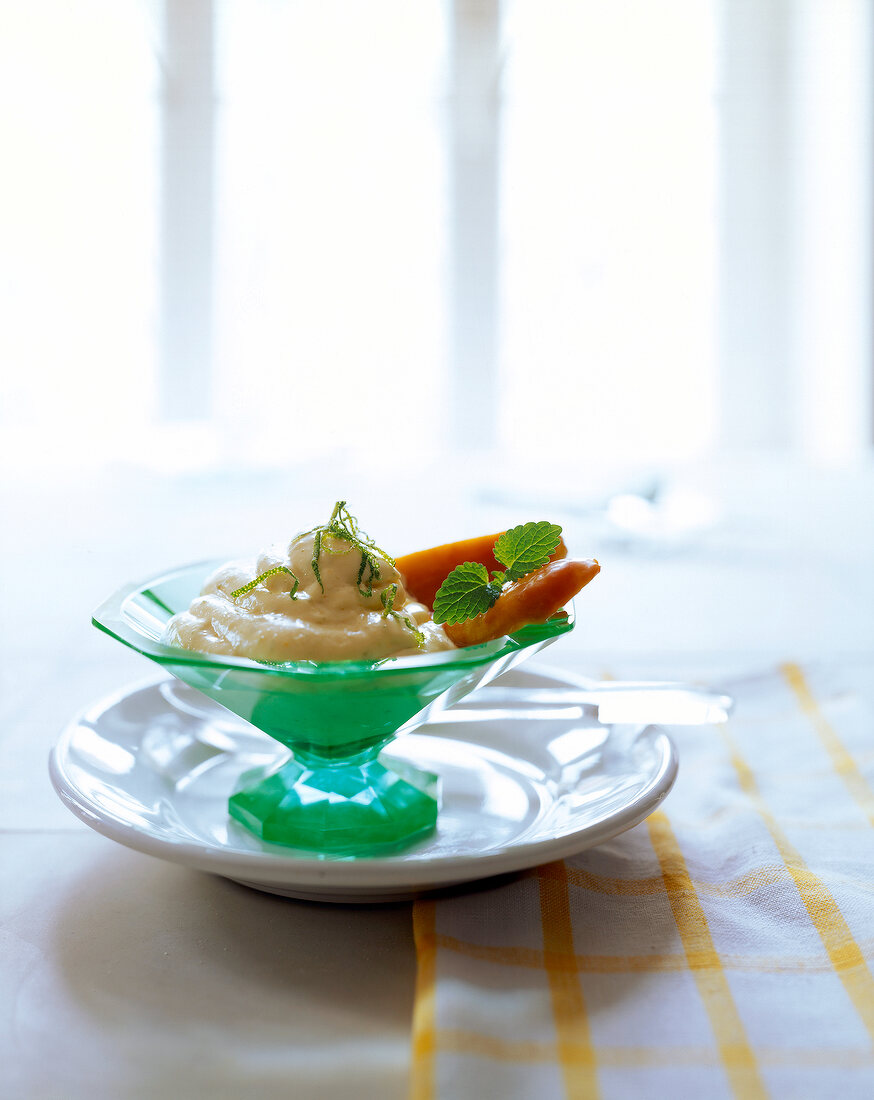 Lime cream with honey banana in a green glass goblet