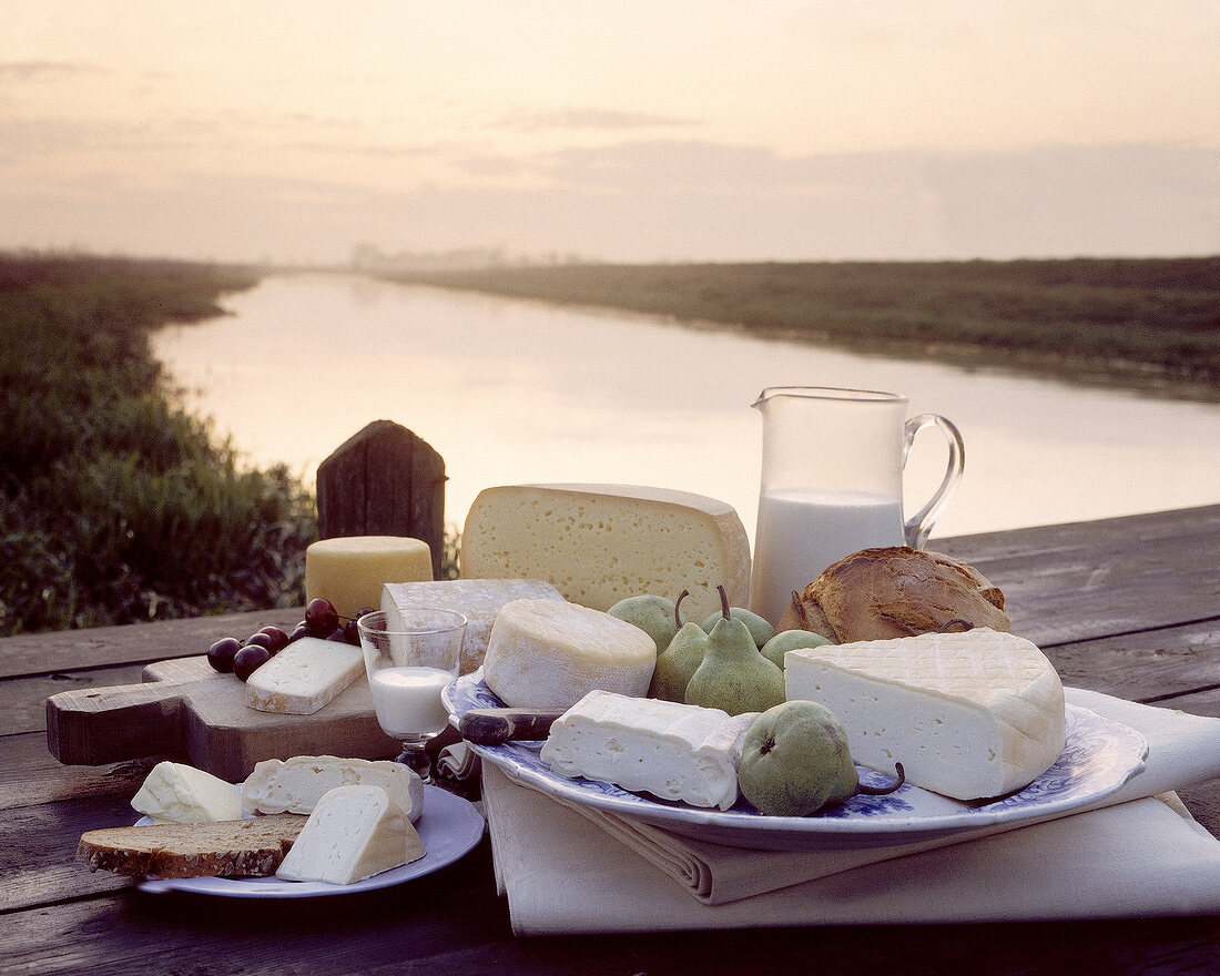 Picknick mit Käse, Milch, Obst und Brot auf einem Bootssteg