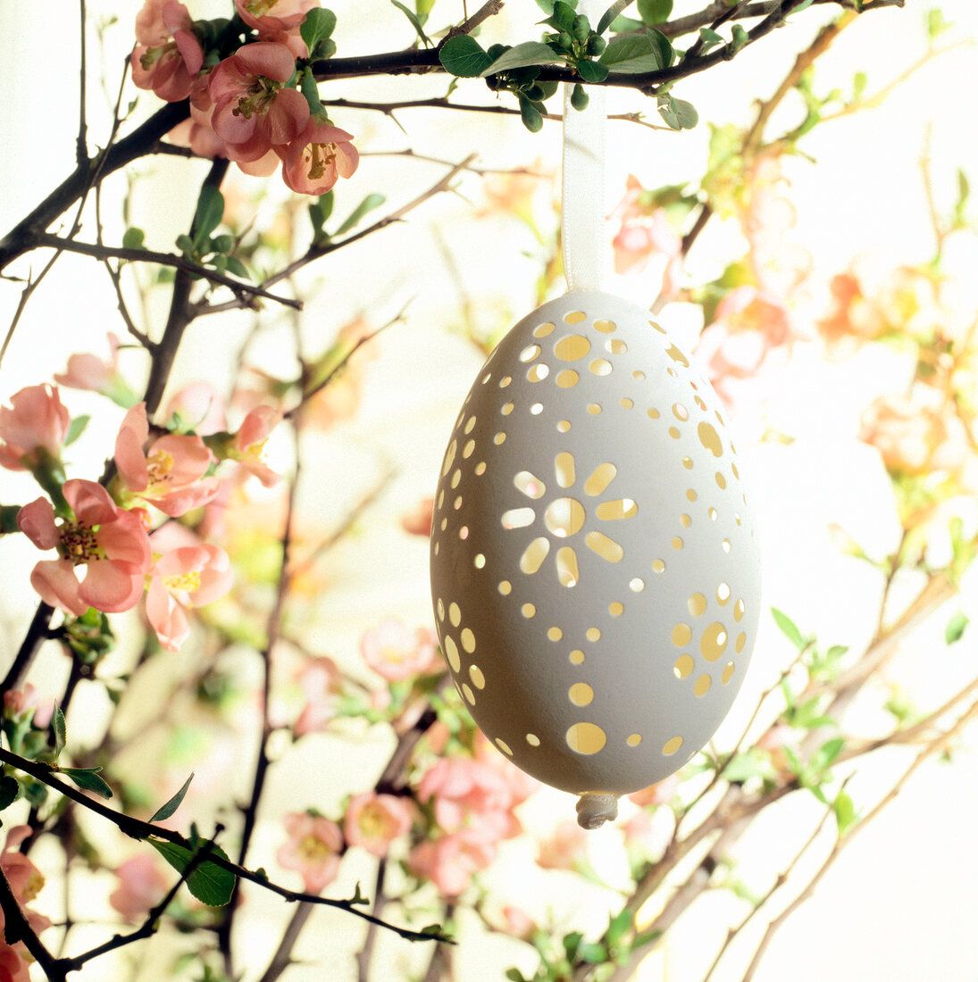 Goose eggs with hole pattern hanging on Easter bouquet