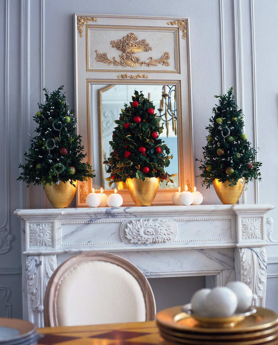 3 kleine Christbaeumchen aus Buxbaum u. Stechpalme auf Kaminsims