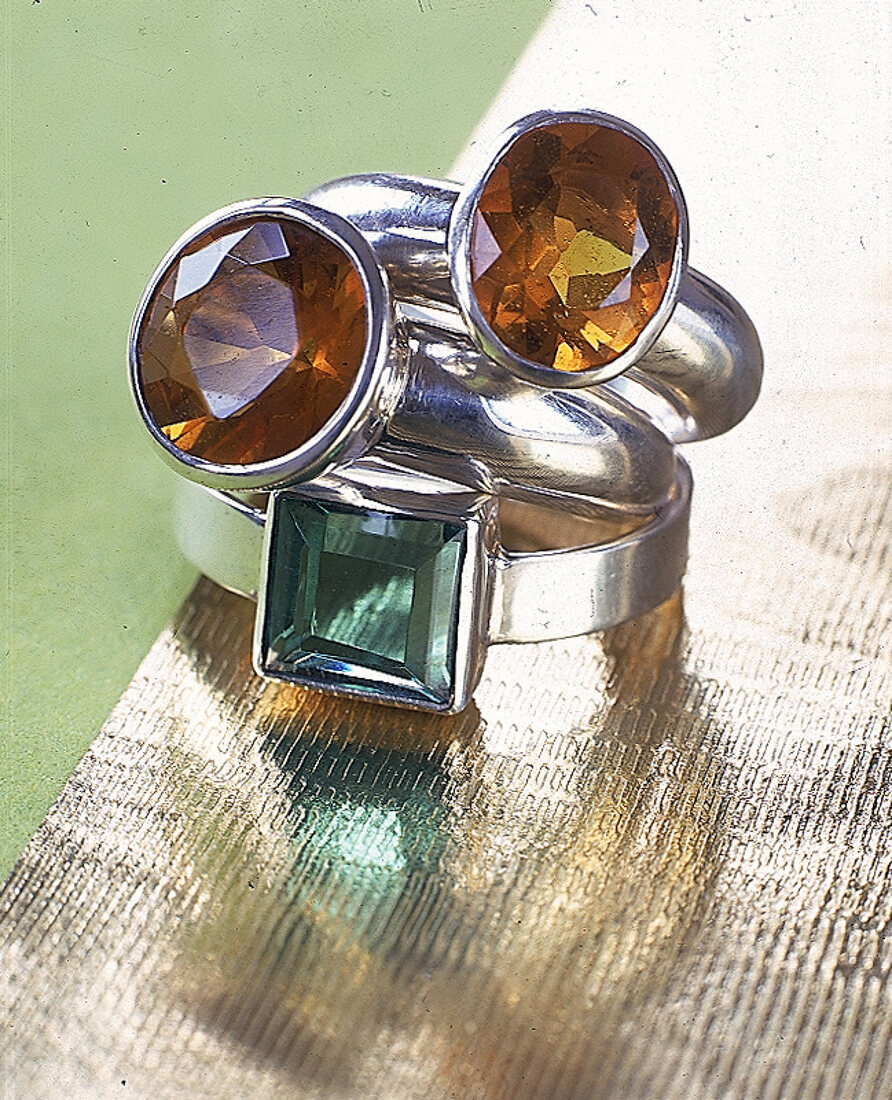 Zwei Silberringe: je mit einem grünen und honigfarbenen Glasstein